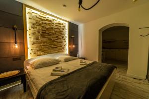 een slaapkamer met een groot bed met een bakstenen muur bij Promenada Apartamenty i Domek Nad Jeziorem in Mikołajki