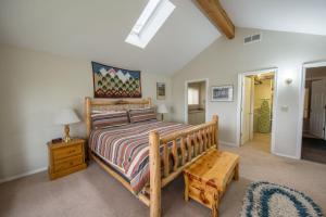 a bedroom with a wooden bed and a wooden bench at Pine Street Cottage in Sisters