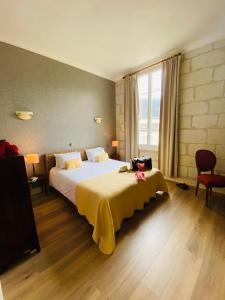 une chambre avec un grand lit avec une couverture jaune dans l'établissement Logis Hôtel Le Plantagenêt, à Chinon