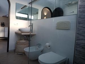 a white bathroom with a toilet and a sink at Leilani Cotillo Garden 2 in El Cotillo