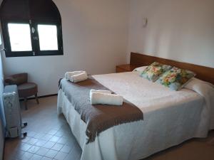 1 dormitorio con 1 cama con 2 toallas en Alana Cotillo Garden 1, en Cotillo