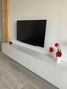 a flat screen tv sitting on top of a white cabinet at Gabriel's Apartment in Constanţa