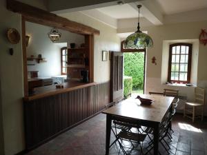 une salle à manger avec une table et une cuisine dans l'établissement Concièrgerie du Château d'Allemagne En Provence, à Allemagne-en-Provence