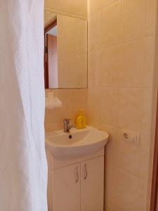y baño con lavabo y espejo. en Mini-Otel Luch en Odesa