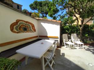una mesa blanca y sillas en un patio en Corsini House, en Levanto