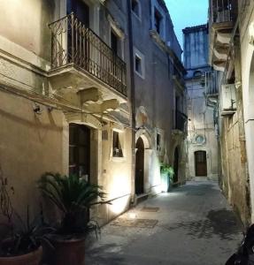 an alley in an old building with a balcony at Appartamento Hortigia in Siracusa