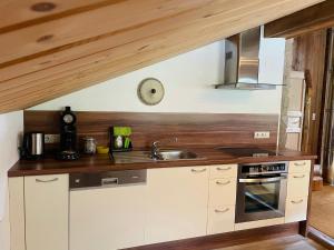 a kitchen with a sink and a stove at Uriges Alpen-Apartment Stefan Juen in See