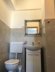 a bathroom with a toilet and a sink and a mirror at Pink Inn in Podstrana +64 photos