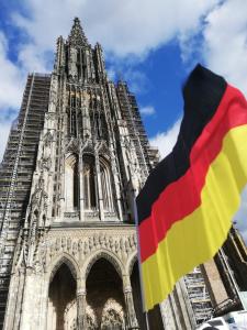 a cathedral with a flag in front of it at Gästehaus Heigeleshof in Ulm +5 photos