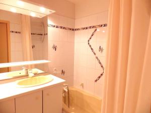 a bathroom with a shower and a sink and a tub at Résidence Chanteneige - Freeloc Immobilier in Les Menuires