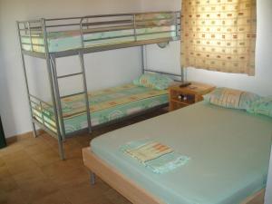 a room with two bunk beds and a table at Eleni Rooms Develiki in Ierissos