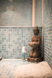 uma estátua de urso numa casa de banho com uma garrafa de sabão em Vitamine Zee em IJmuiden