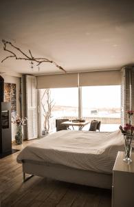 a bedroom with a large bed and a large window at Vitamine Zee in IJmuiden