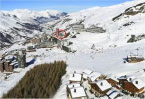 a ski resort with a red sign in the snow at Les Lauzes - Freeloc Immobilier in Les Menuires