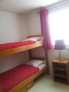 two bunk beds in a room with a window at Les Lauzes - Freeloc Immobilier in Les Menuires