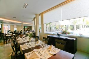 ein Restaurant mit Tischen und Stühlen und einem großen Fenster in der Unterkunft Quorum Córdoba Hotel, Resort Urbano in Cordoba