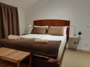 um quarto com uma cama grande e uma cabeceira em madeira em B&B La Fosina em Mezzolombardo