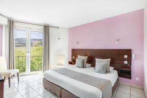 a bedroom with a large bed and a large window at La Frégate in Collioure