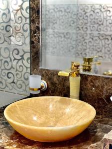 a sink in a bathroom with a gold faucet at Asian Hotel in Duqm