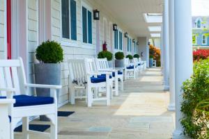 - une rangée de chaises blanches sur une terrasse couverte dans l'établissement Southampton Village Motel, à Southampton