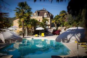 a house with a swimming pool in front of a house at Les Magnolias holiday homes in Lalinde