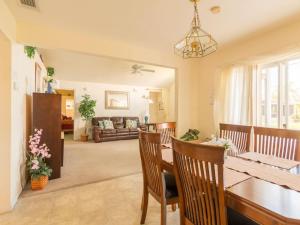 a dining room and living room with a table and chairs at Sunshine, Love, And Happiness In A Home Thats Cute As A Button - 3bd 2552 in Kissimmee