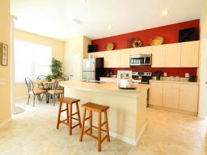 a kitchen with a counter and stools in a room at 4 Bed 2245 in Kissimmee