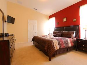 1 dormitorio con 1 cama con pared roja en 4 Bed 2245, en Kissimmee