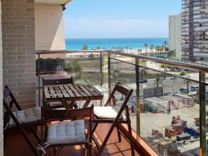 balcón con mesa y sillas y la playa en Apartamento con vistas al mar, en Alicante