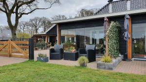 a house with a bunch of chairs on a patio at B&B Hertenhoef, Fluitenberg (Hoogeveen) in Fluitenberg +53 photos
