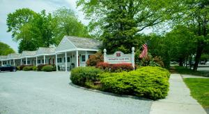 uma casa com um sinal e uma bandeira americana em Southampton Village Motel em Southampton