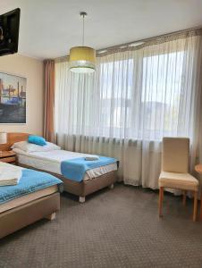 een hotelkamer met 2 bedden en een raam bij RB Rooms&Apartments in Bydgoszcz