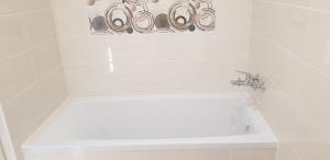 un bagno bianco con vasca e lavandino di Narva Appart a Narva