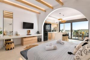 a bedroom with a large bed and a kitchen at Pefkos Allure Luxury Suites with Jacuzzi in the heart of Pefkos!!! in Pefki Rhodes