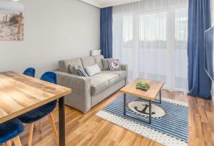 a living room with a couch and a table at FARO Apartamenty Kasprowicza 20 in Kołobrzeg