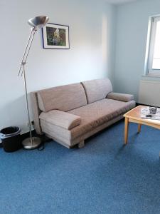 a living room with a couch and a lamp at Ferienwohnung 4, Waldesruh Dierhagen in Dierhagen +7 photos