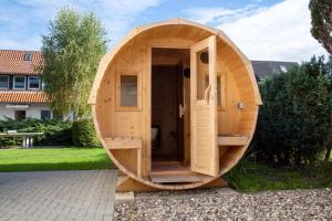 a wooden sauna with a wooden door in a yard at Ferienwohnung 4, Waldesruh Dierhagen in Dierhagen