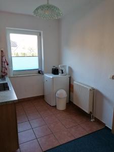 a kitchen with a small refrigerator and a window at Ferienwohnung 4, Waldesruh Dierhagen in Dierhagen