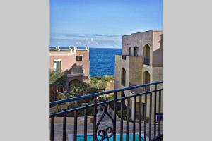 a view of the ocean from a balcony at Sunny Apartment in Tas-Sellum Mellieha, Malta. in Għajn Żejtuna