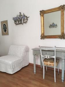 Habitación con mesa, espejo y taburete. en Affittacamere Arco Polinori, en Foligno