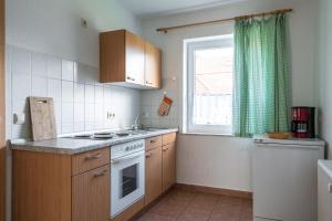 a kitchen with a stove and a sink and a window at Ferienwohnung 4, Waldesruh Dierhagen in Dierhagen