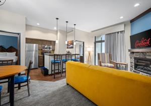 a living room with a yellow couch and a kitchen at Camelback Resort in Tannersville