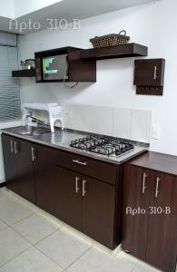 eine Küche mit einem Kochfeld in der Unterkunft GUADUALES DEL CAFÉ, hermoso apartamento 310B en el Eje Cafetero in Montenegro