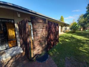 a house with a wooden door on the side of it at Flutterby Guesthouse in Potchefstroom