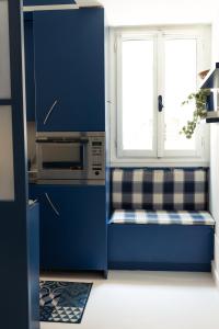 a blue kitchen with a bench in front of a window at BlueYellow home in Cannaregio Air conditioning WiFi in Venice