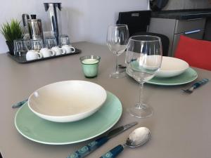 a table with two plates and wine glasses on it at Balatonlelle Apartmanház in Balatonlelle +70 photos