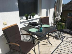 a black table and chairs on a patio at Balatonlelle Apartmanház in Balatonlelle