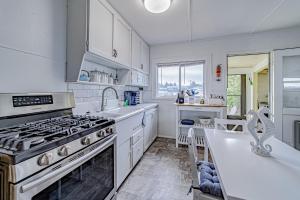 uma cozinha branca com um fogão e um lavatório em Driftwood Cottage em Eureka