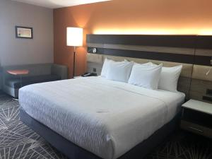 um quarto de hotel com uma cama grande com almofadas brancas em La Quinta by Wyndham Branson em Branson