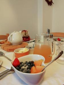 un tavolo con un cesto di frutta e una brocca di succo di B&B Le Fontane Fam. Degan a Carzano